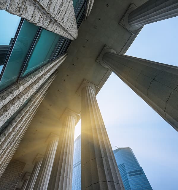 Image of sun behind columns of a government building